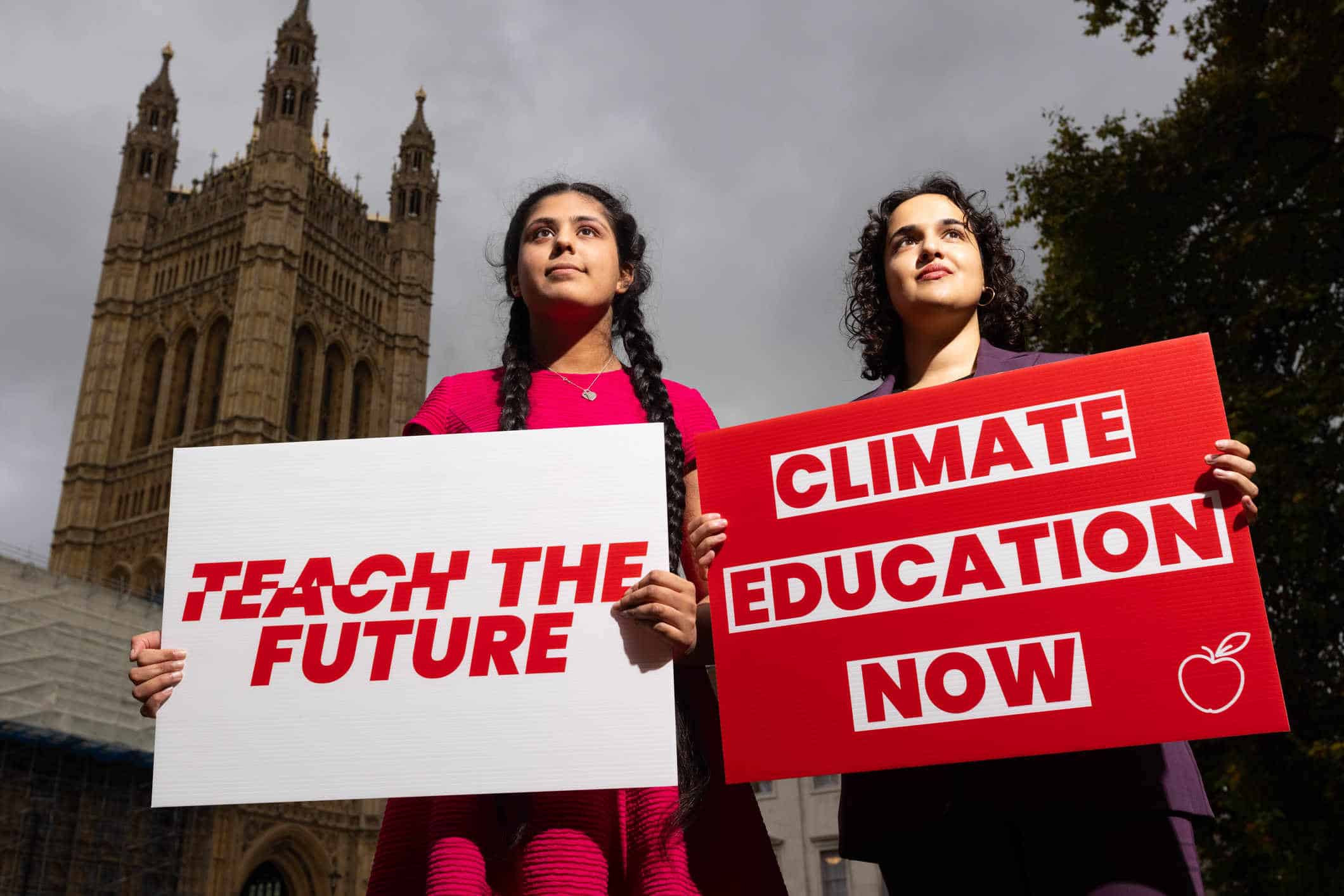 Scarlett Westbrook and Nadia Whittome hold Teach the Future placardass before the parliamentary reception.