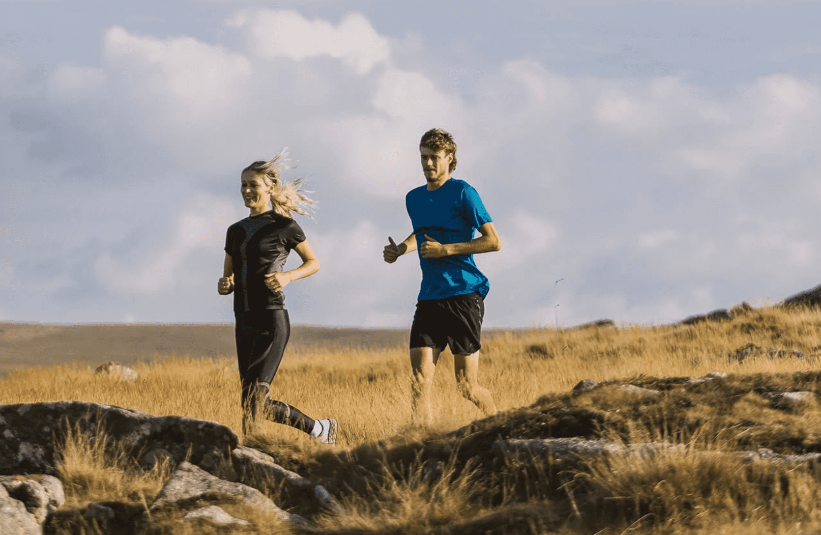 Woman and man running in field wearing sustainable sports brand Presca
